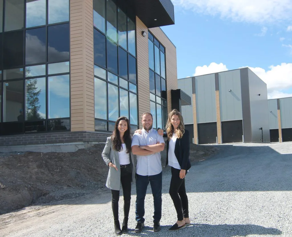 Trois membres de l'équipe Modulo devant le bâtiment